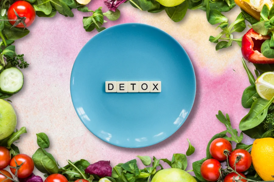 detox on a blue plate with a lot of fresh fruit and vegetables around